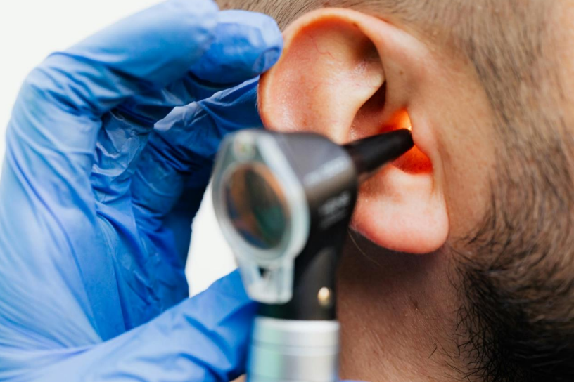 Picture of an otoscope being inserted into an ear.