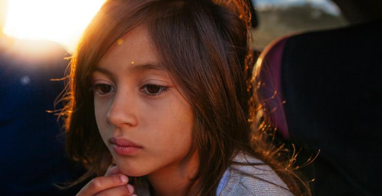 Girl sitting in car looking sad