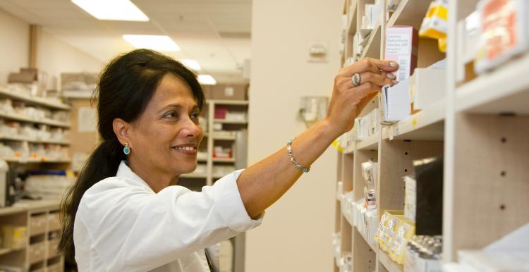 Pharmacist takes medication off shelf