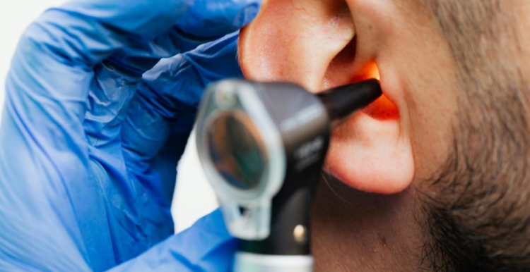 Picture of an otoscope being inserted into an ear.
