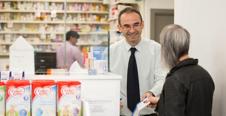pharmacist handing out prescription