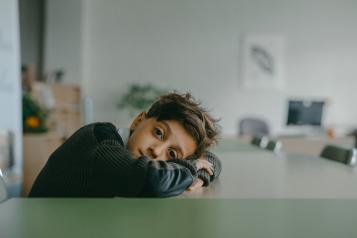 Sad boy rests head on table