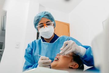 Dentist examines patient's teeth