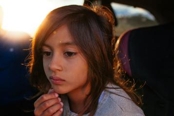 Girl sitting in car looking sad