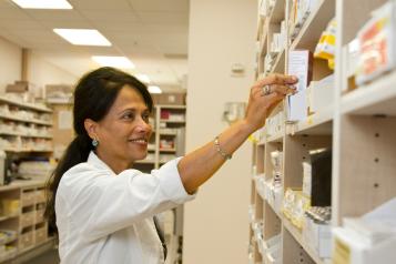 Pharmacist takes medication off shelf