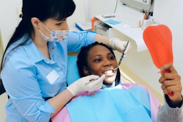 Woman at the dentist looks in a mirror