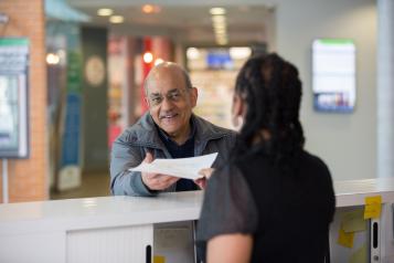 elderly man talking to receptionist