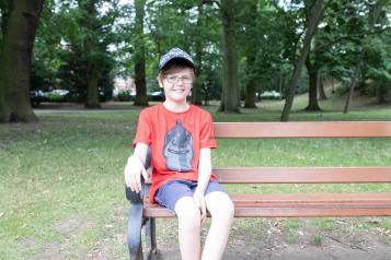 young boy sitting on a bench
