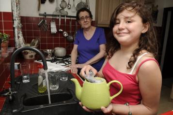 A young female carer helping her mum in the kitchen