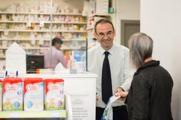 pharmacist handing out prescription