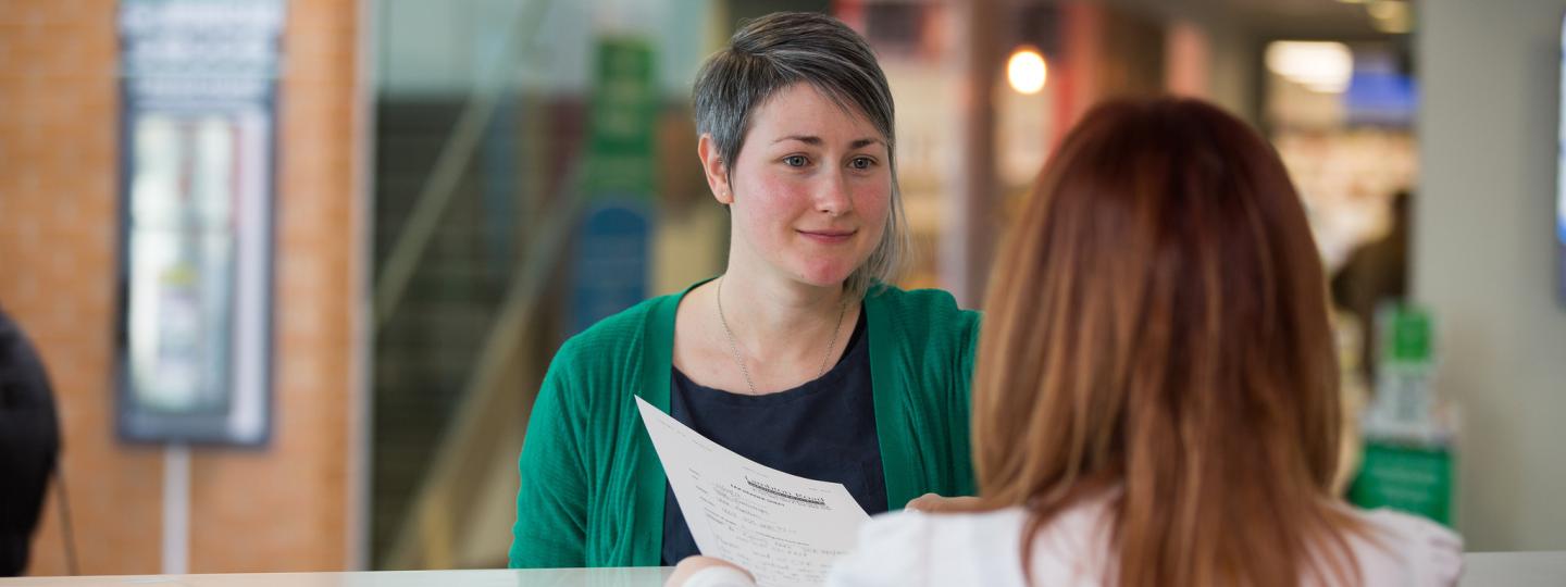 Woman speaking to a receptionist