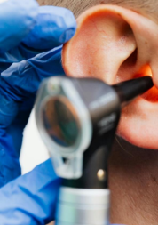Picture of an otoscope being inserted into an ear.